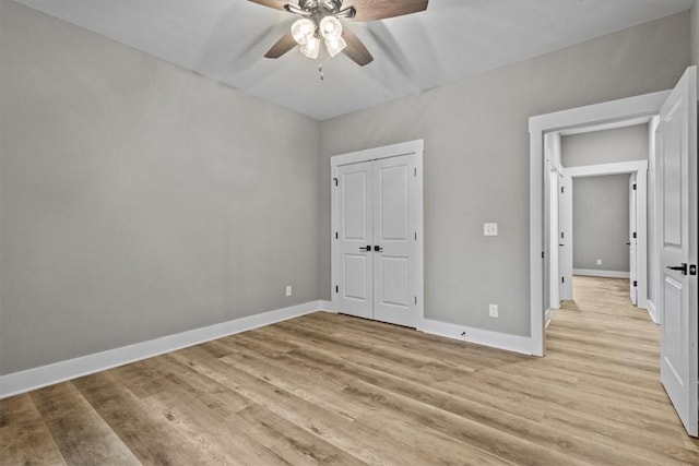 unfurnished bedroom featuring a closet, ceiling fan, and light hardwood / wood-style flooring