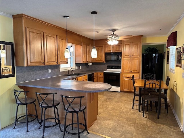 kitchen with sink, kitchen peninsula, decorative light fixtures, a kitchen bar, and black appliances