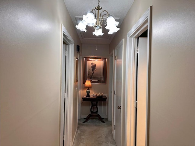 hallway with a chandelier and light colored carpet