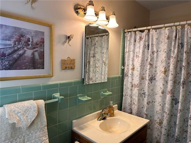 bathroom featuring a shower with curtain, vanity, and tile walls