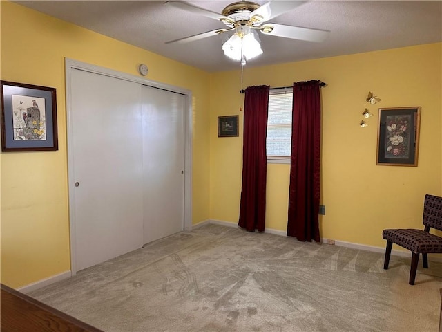 interior space featuring ceiling fan and light carpet