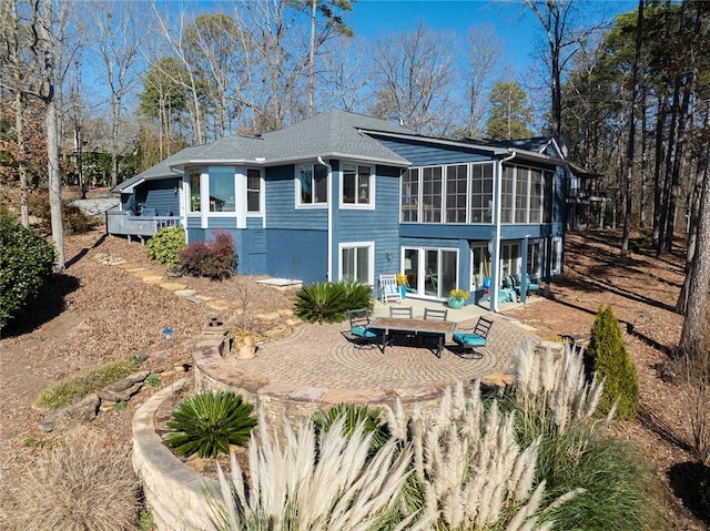 rear view of house featuring a sunroom and a patio