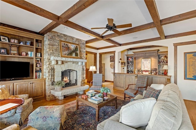 living room with a fireplace, beam ceiling, light hardwood / wood-style flooring, and coffered ceiling