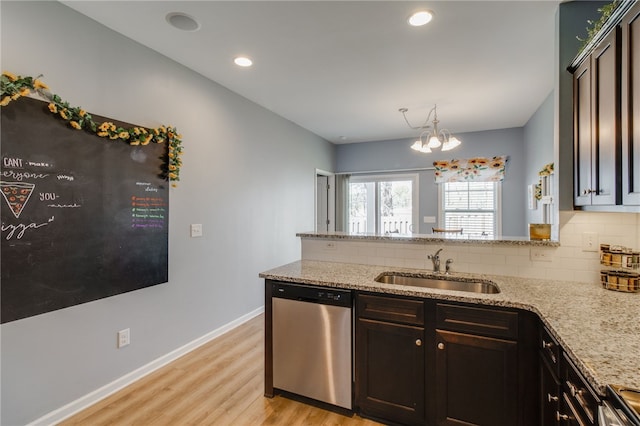 kitchen with dishwasher, sink, a chandelier, dark brown cabinets, and light wood-type flooring