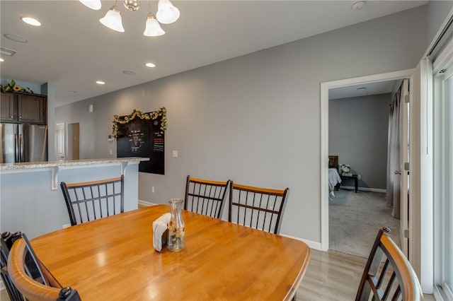 dining area featuring light hardwood / wood-style floors and a chandelier