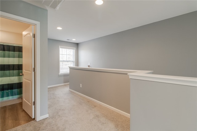 corridor featuring light colored carpet