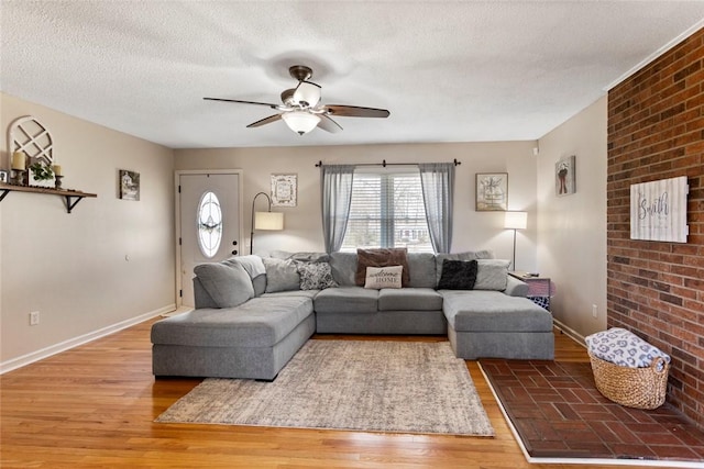 living room with ceiling fan, wood-type flooring, and a textured ceiling