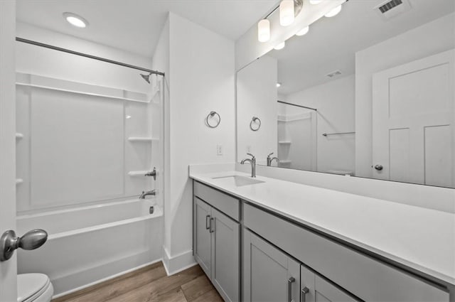 full bathroom with hardwood / wood-style floors, vanity, toilet, and bathing tub / shower combination