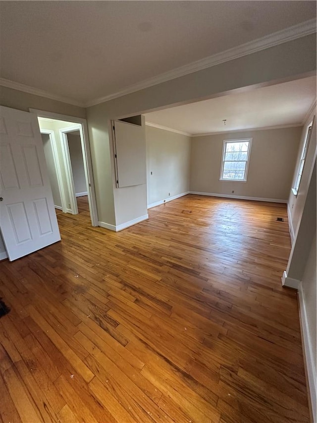 unfurnished room with ornamental molding and light wood-type flooring