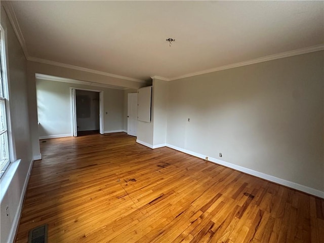 empty room with ornamental molding and light hardwood / wood-style floors