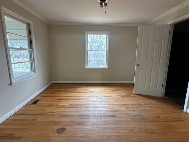 unfurnished room with light wood-type flooring, crown molding, and a healthy amount of sunlight