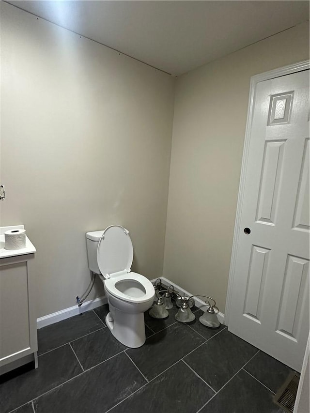 bathroom with toilet, vanity, and tile patterned floors