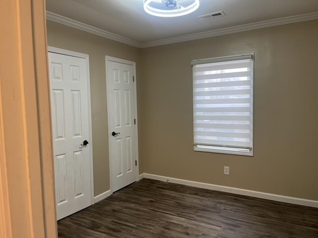 unfurnished bedroom with dark hardwood / wood-style floors, ornamental molding, and multiple windows