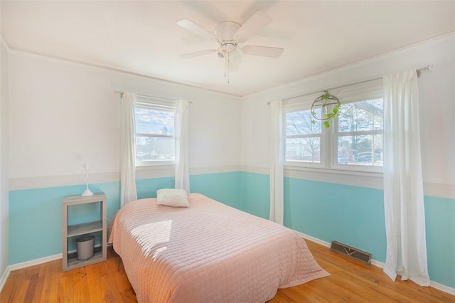 bedroom featuring ceiling fan, crown molding, and wood-type flooring