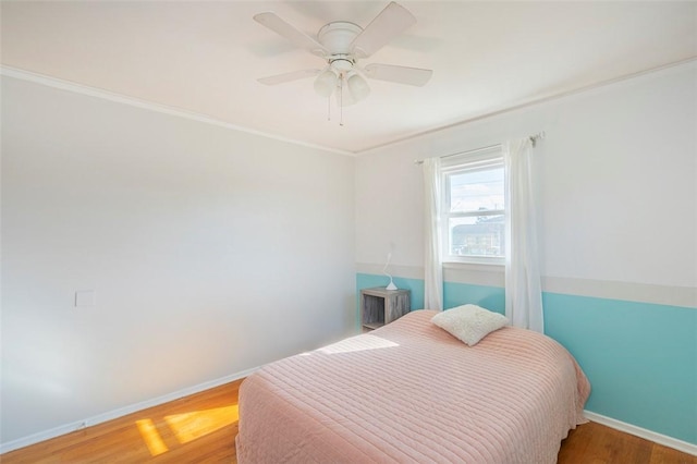 bedroom with hardwood / wood-style floors, ceiling fan, and crown molding