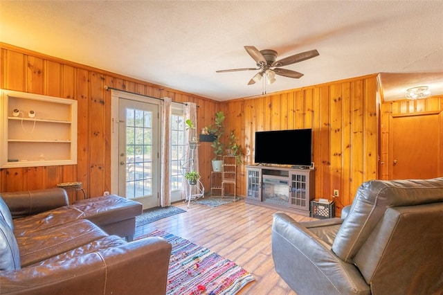 living room with hardwood / wood-style floors, ceiling fan, and a textured ceiling