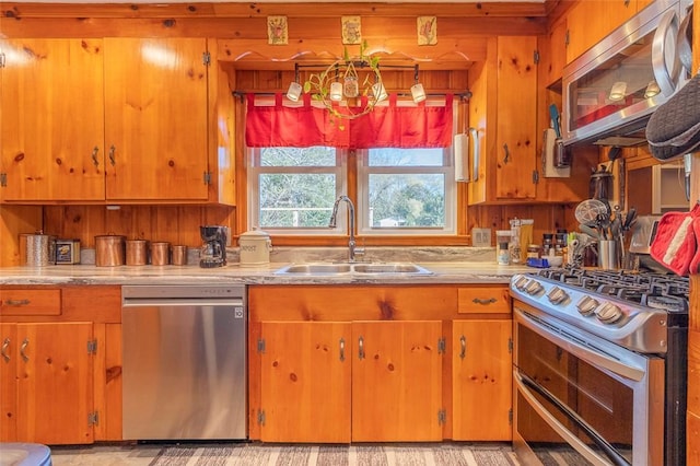 kitchen featuring wood walls, sink, and stainless steel appliances