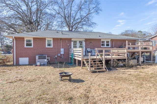 back of house with a deck and an outdoor fire pit