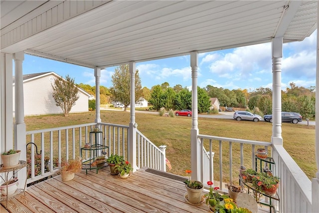 wooden deck featuring covered porch and a yard