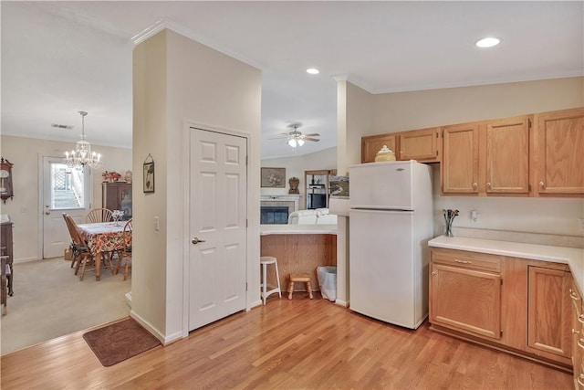 kitchen with ceiling fan with notable chandelier, white refrigerator, vaulted ceiling, and ornamental molding