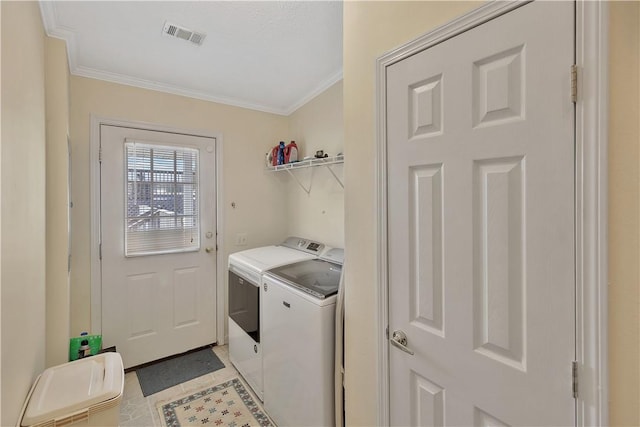 clothes washing area featuring washer and clothes dryer, light tile patterned floors, and ornamental molding