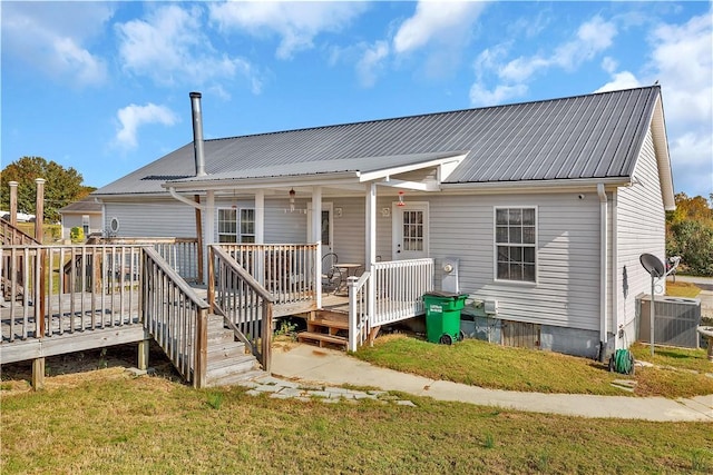 rear view of house with a lawn, cooling unit, and a deck