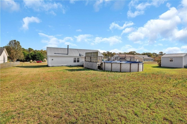 rear view of house featuring a yard and a covered pool