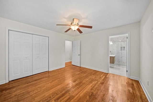 unfurnished bedroom featuring light wood-type flooring, connected bathroom, a closet, and ceiling fan