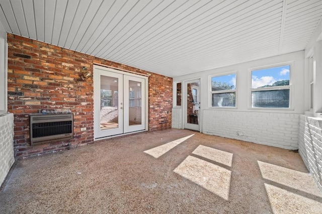 unfurnished sunroom featuring french doors, a fireplace, and heating unit