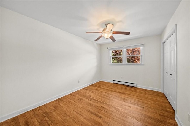 unfurnished bedroom featuring baseboard heating, a closet, ceiling fan, and light hardwood / wood-style flooring