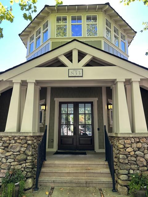 view of exterior entry featuring french doors and a porch