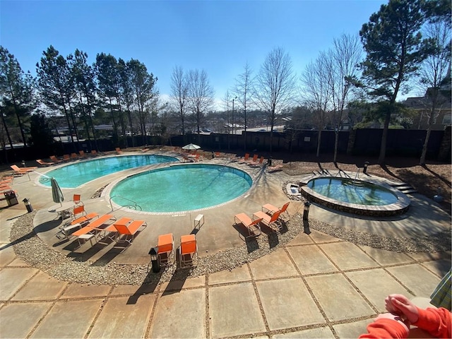 view of pool with a patio area and a hot tub