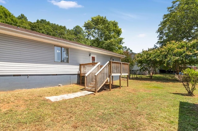 rear view of house with a lawn and a wooden deck