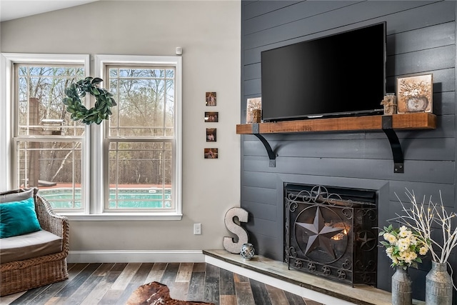 living room with hardwood / wood-style flooring, wood walls, a wealth of natural light, and vaulted ceiling