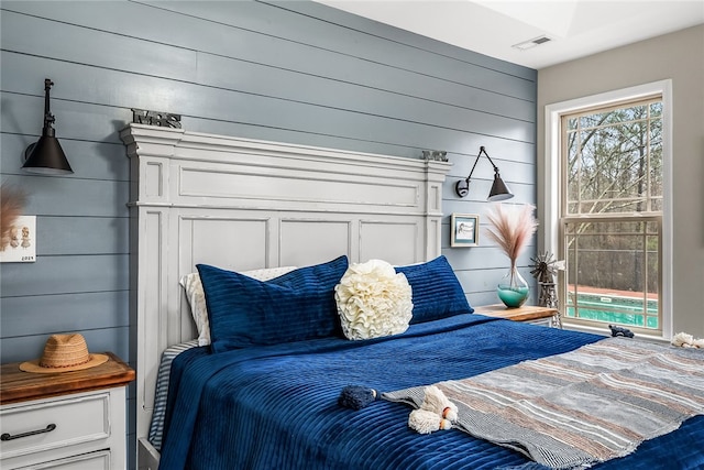 bedroom featuring wood walls