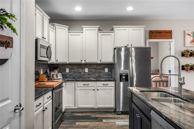 kitchen with white cabinetry, sink, appliances with stainless steel finishes, and tasteful backsplash