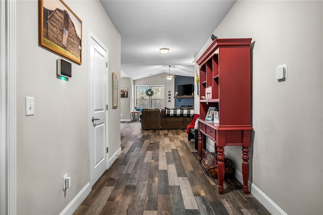 corridor with lofted ceiling and dark wood-type flooring