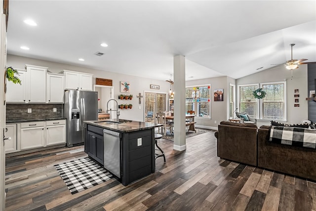 kitchen featuring a kitchen island with sink, a kitchen breakfast bar, sink, vaulted ceiling, and stainless steel appliances