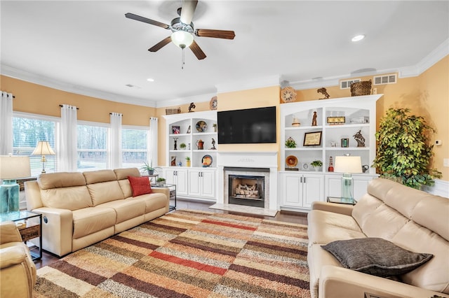 living room with ceiling fan, light wood-type flooring, and crown molding