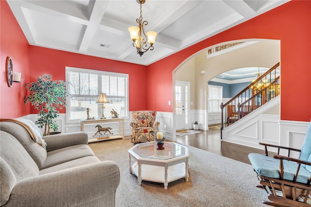 living room with carpet floors, beamed ceiling, coffered ceiling, and a notable chandelier