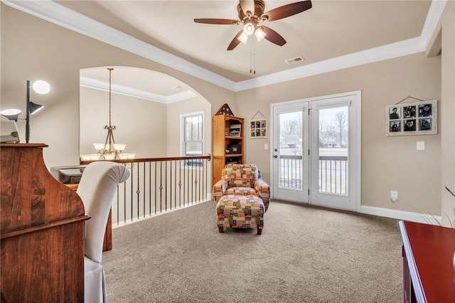 sitting room featuring carpet flooring, ceiling fan with notable chandelier, and crown molding