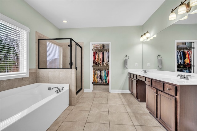 bathroom featuring tile patterned flooring, vanity, a healthy amount of sunlight, and plus walk in shower