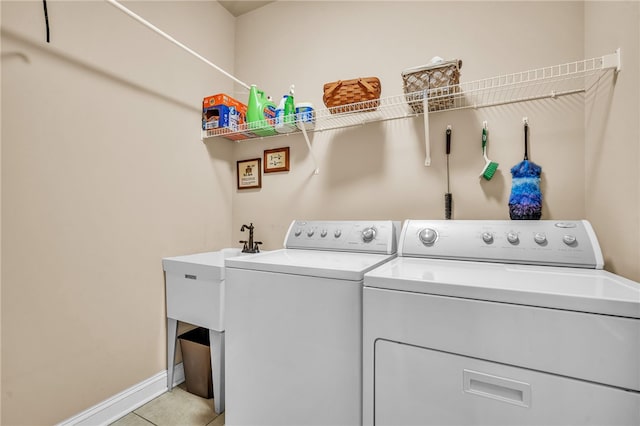 clothes washing area with light tile patterned floors and washer and clothes dryer