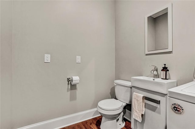 bathroom with hardwood / wood-style floors, vanity, and toilet