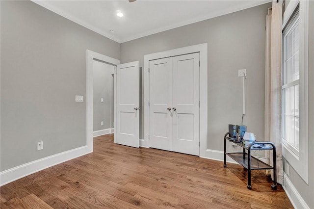 bedroom with crown molding, a closet, and light hardwood / wood-style floors