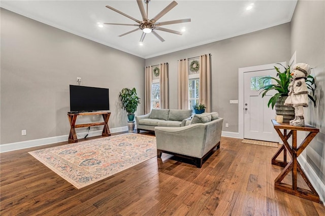 living room with hardwood / wood-style flooring, ceiling fan, and ornamental molding