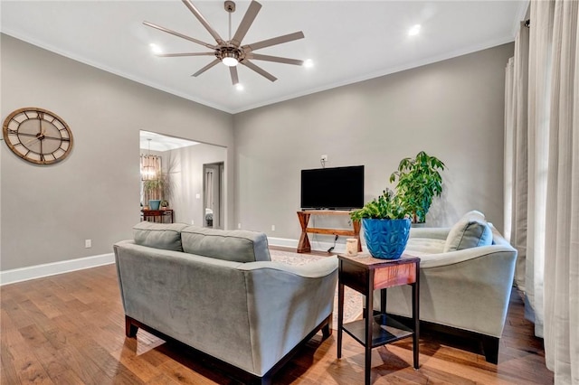 living room featuring ceiling fan, ornamental molding, and hardwood / wood-style flooring