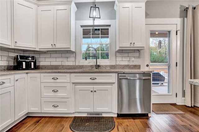 kitchen featuring dishwasher, white cabinets, hanging light fixtures, and sink