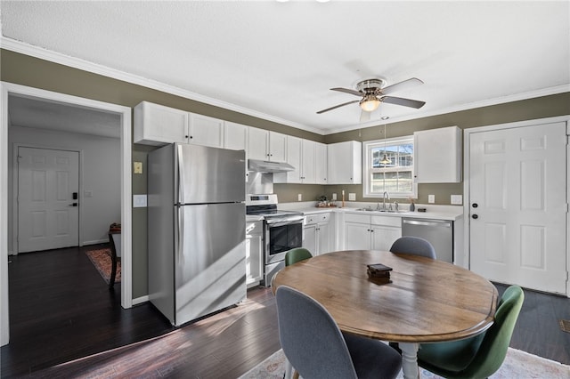 kitchen with appliances with stainless steel finishes, ceiling fan, dark wood-type flooring, sink, and white cabinetry