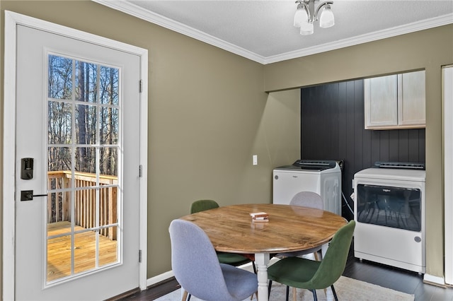 dining space featuring dark hardwood / wood-style flooring, a textured ceiling, crown molding, an inviting chandelier, and washing machine and clothes dryer